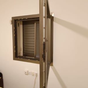 תריסים חומים פתוחים על חלון קיר לבן