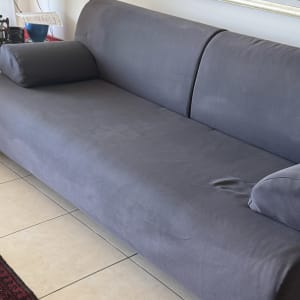 ספה אפורה נקייה עם כריות על רצפת אריחים