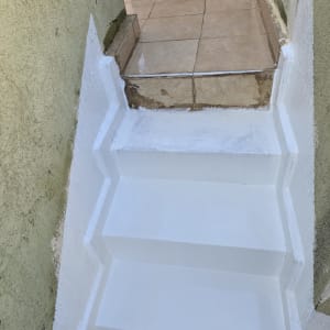 מדרגות צבועות בלבן עם איטום סביב האריחים