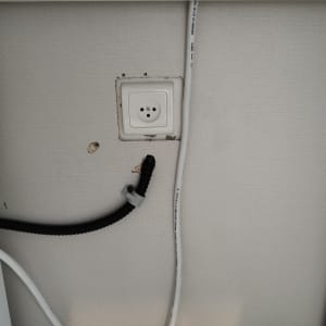 שקע חשמל, כבלים וכלי עבודה על קיר