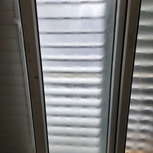 זכוכית מחוספסת במסגרת חלון לבנה