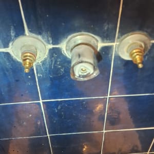 ברזים וכלי עבודה על קיר אריחים כחול