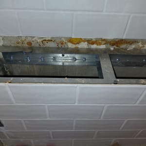 בניית קונסטרוקציית מתכת בתוך נישה בקיר מחופה אריחי קרמיקה לבנים