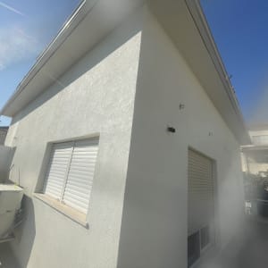 קיר חיצוני של מבנה עם חלונות ותריסים סגורים