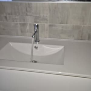 ברז מים זורם בכיור בחדר אמבטיה