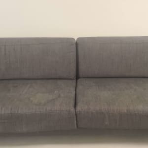 ספה אפורה עם כתמים על המושב