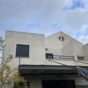 פרגולה מאלומיניום מחוברת לקיר חיצוני של בית