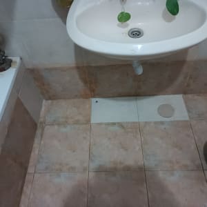 כיור עם צינור, כתמי רטיבות על הקיר והרצפה