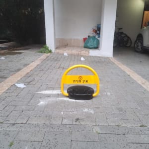 מחסום חניה צהוב עם כיתוב אין חניה