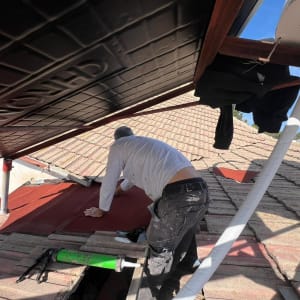 עובד מבצע עבודות גג עם כלים וחומרים