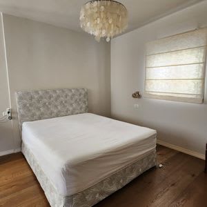 מיטה עם מזרן לבן בחדר שינה