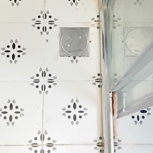 רצפת אריחים עם ניקוז וזכוכית במקלחת