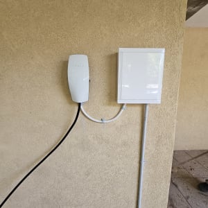 מטען טסלה מותקן על קיר עם כבלים חשמליים