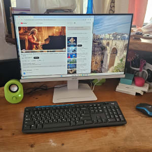 שולחן עבודה עם מחשב, מקלדת ורמקולים ירוקים