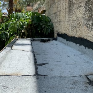 גג אטום עם שכבת זפת שחורה לאורך הקיר