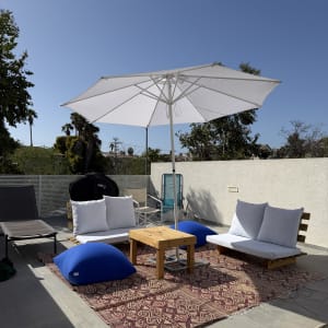 פינת ישיבה חיצונית עם שמשייה וכריות