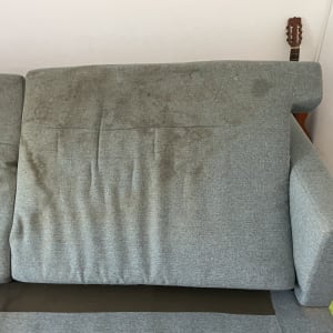ספה אפורה עם כתמים ולכלוך גלוי