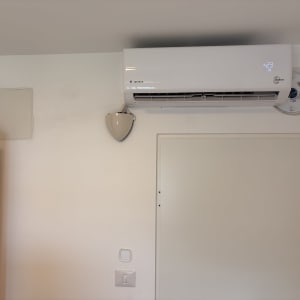 מזגן מותקן על קיר לבן בחדר