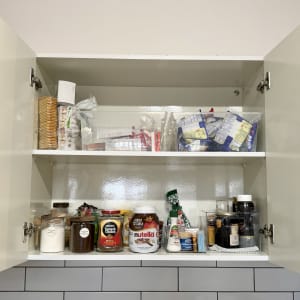 ארון מטבח פתוח עם מוצרי מזון מסודרים על מדפים