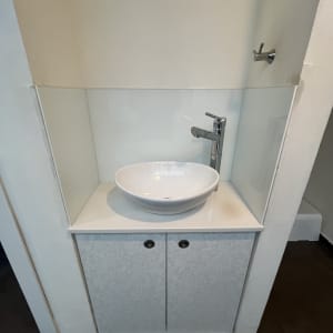 כיור עם חיפוי זכוכית מאחוריו