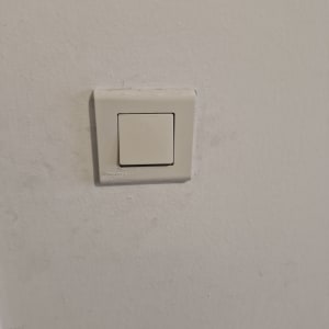 מתג חשמל לבן על קיר לבן