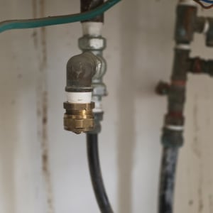 תקריב של חיבורי צנרת ואיטום טפלון בדוד מים