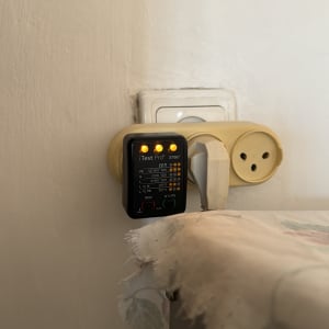 בודק שקעים חשמלי מחובר לשקע בקיר