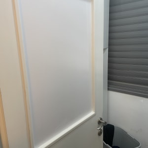 דלת לבנה עם ידית מתכת בחדר פנימי