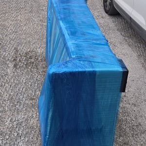 רהיט עטוף בניילון כחול ליד מכוניות חונות