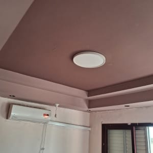 תקרת גבס מונמכת וקירות צבועים בגוון דקורטיבי בחדר מגורים