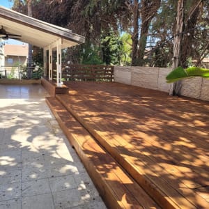 דק עץ בגינה עם מדרגות ופרגולה