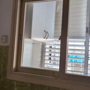 חלון זכוכית עם תריסים פתוחים חלקית