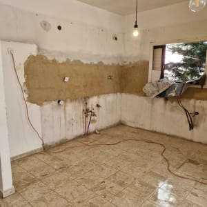 חדר ריק עם קירות חשופים ותשתיות חשמל