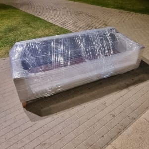 ספה עטופה בניילון על מדרכה בלילה