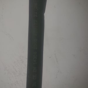 צינור שחור עם כיתוב לבן על רקע קיר לבן