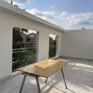 מרפסת עם שולחן עץ, כיסאות וכלים לניקוי