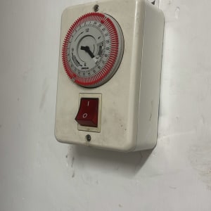 שעון טיימר חשמלי עם מתג הפעלה על קיר