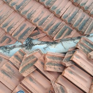 רעפים שבורים על גג עם לכלוך ופסולת