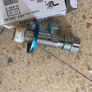 ברז זוויתי מונח על רצפה ליד קופסה