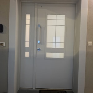 דלת לבנה עם חלונות זכוכית ומנעול כסוף