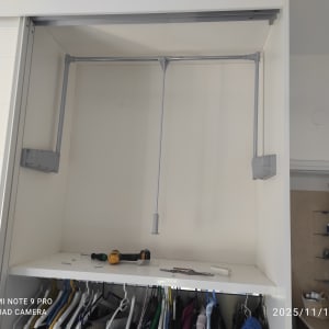 ארון בגדים עם מוטות תלייה וכלי עבודה על המדף