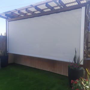 סוכך חיצוני מותקן בחצר עם צמחים מסביב