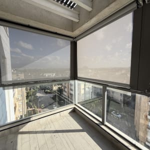 מרפסת עם סוככים שקופים לנוף עירוני