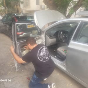 מנעולן רכב עובד על תיקון מנגנון נעילה בדלת רכב