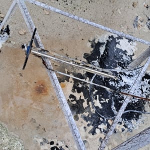 מבנה מתכת חלוד עם צינור על קרקע חולית