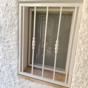 חלון עם סורגי אלומיניום על קיר לבן