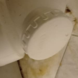 חיבור צינור פלסטיק לבן עם כתמים על הרצפה