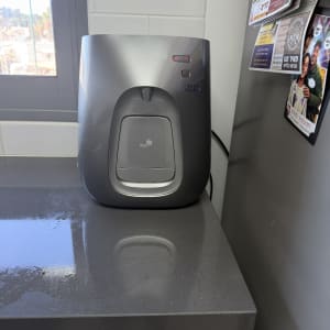 מכשיר מים על משטח במטבח ליד חלון