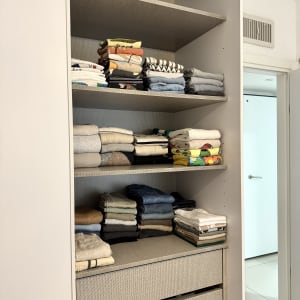 בגדים מקופלים בארון על מדפים מסודרים