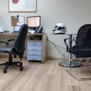 משרד עם רצפת פרקט בהירה ושולחנות עבודה